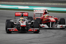 Lewis Hamilton races with Fernando Alonso at Sepang