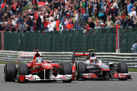 Fernando Alonso is passed by Jenson Button at Spa