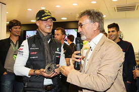 Eddie Jordan presents Michael Schumacher with a souvenir clutch