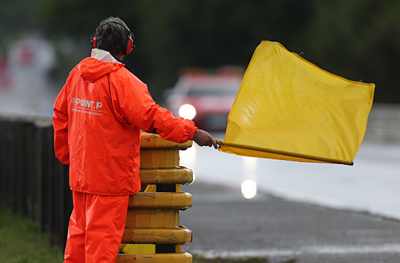 A marshal waves a yellow flag at Le Mans